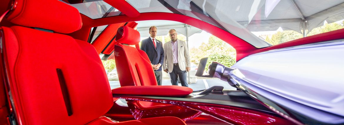 Peachtree Corners, Georgia two men looking at a high tech automobile with red seats.
