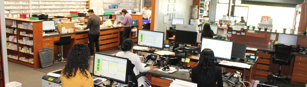 Baybridge Pharmacy Corp. employees working at computers and counters.