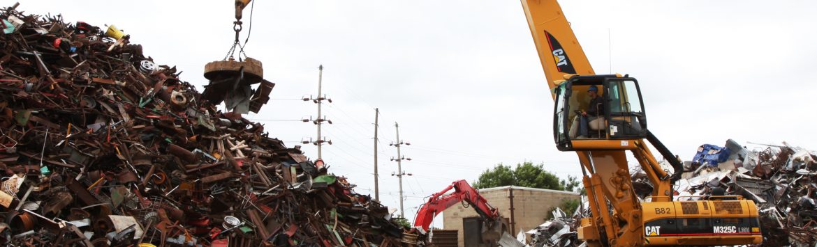 M. Gervich & Sons, Inc. crane with magnet moving scrap metal from a pile.
