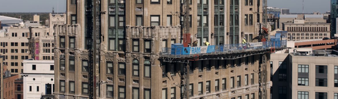 RAM Construction Services Kamper Building work with scaffolding that says RAM Construction on it.