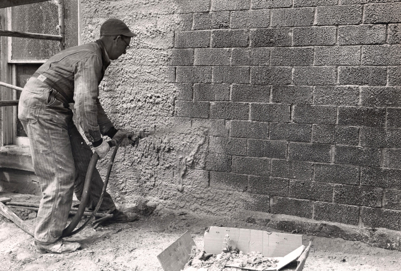 RAM Construction Services vintage black and white photo of spraying material on the exterior of a building.