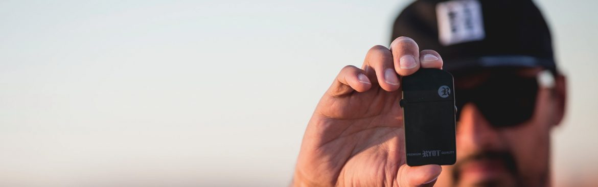 RYOT Dan holding a RYOT lighter with his face out of focus.