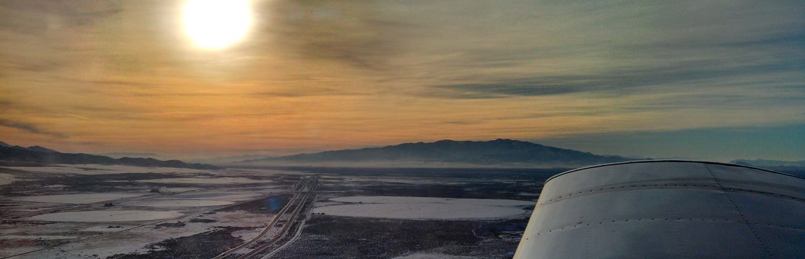 The Winnemucca Municipal Airport stock photos of a view from a plane over the airport with the sun in the background.