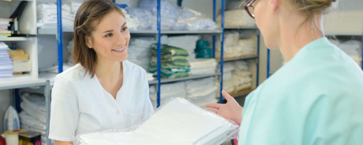 Healthcare Laundry Accreditation Council HLAC Nurse taking clean sheets from hospital laundry
