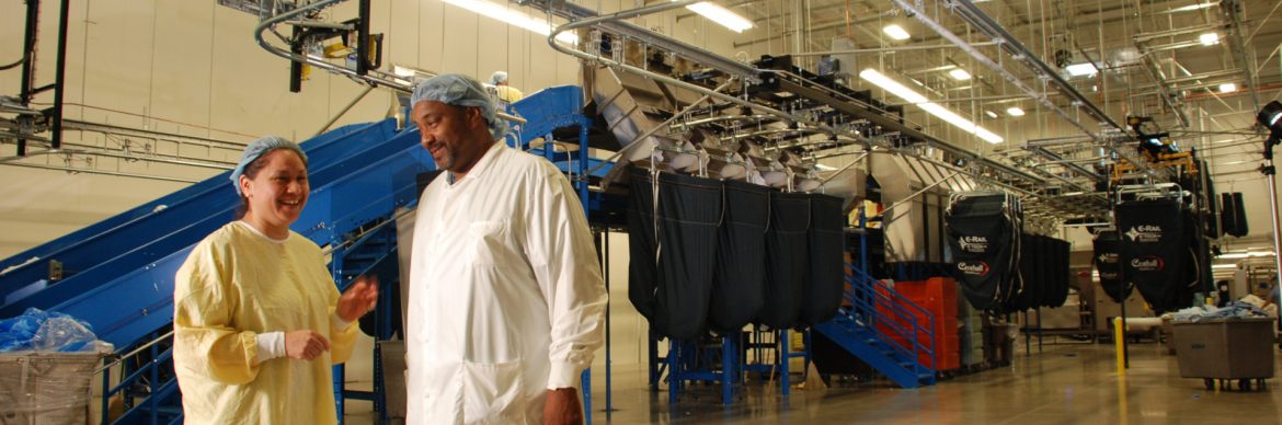 Crothall Laundry and Linen Services employees in front of equipment.