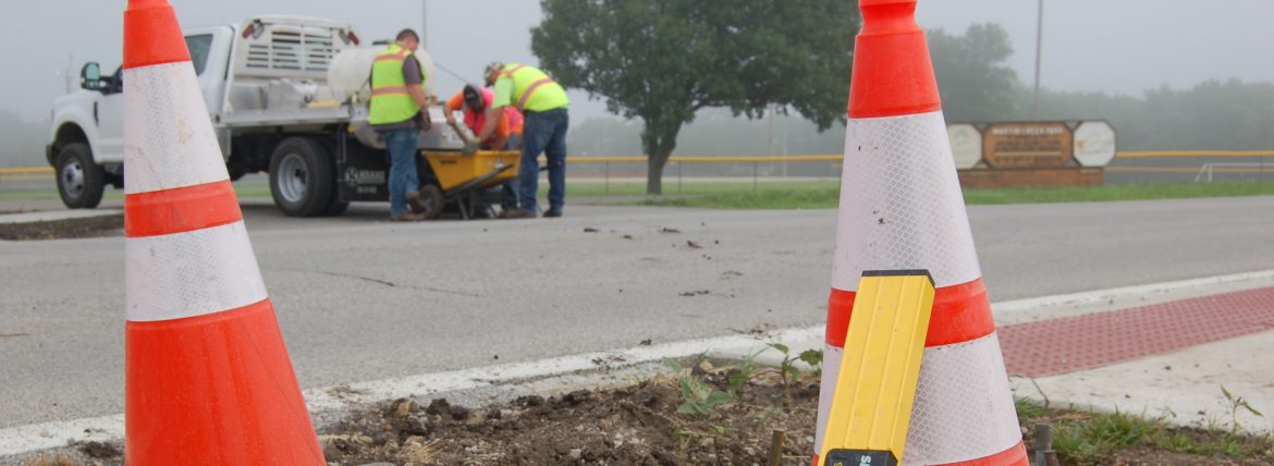 Edgerton, Kansas two orange cones up close and men working from a truck across the street.