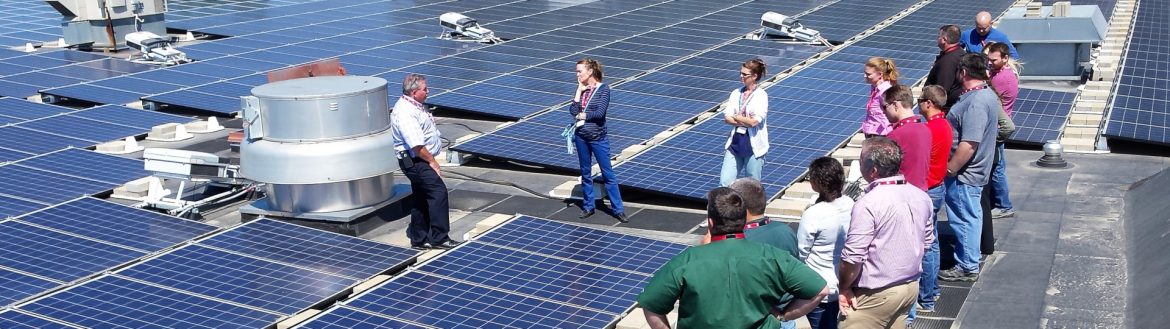 Iowa Sustainable Business Forum rooftop meeting with a group of people with solar panels on the roof.