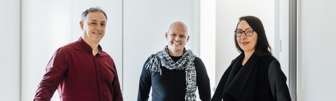 Destination Living 3 people standing for a photo.