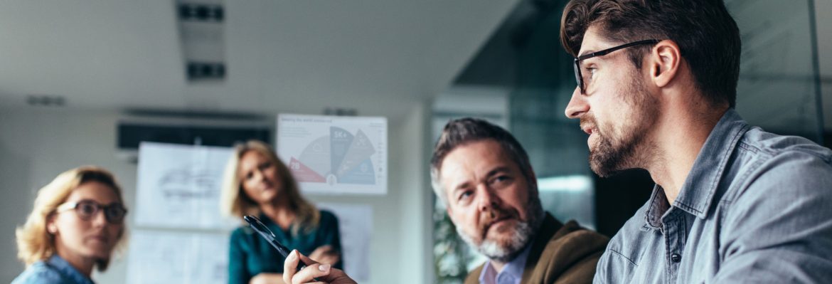 iconectiv four people talking at a meeting with graphs behind.