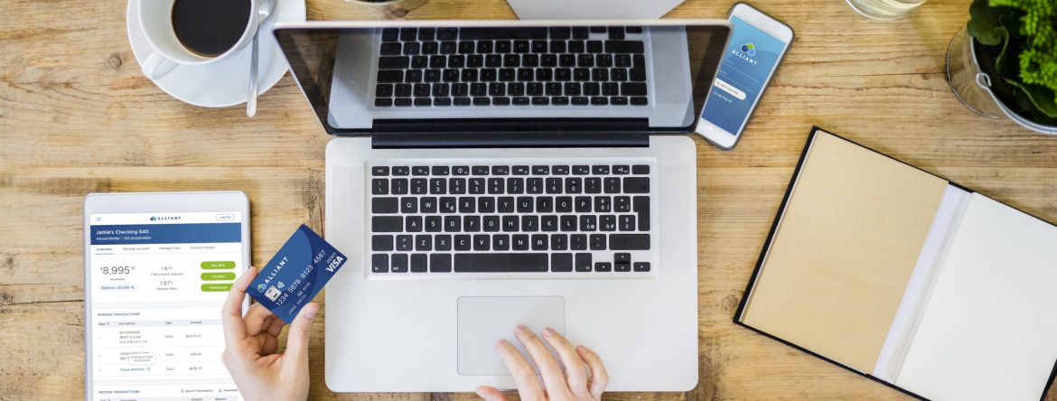 Alliant Credit Union - stock photo showing a persons hands in front of a laptop holding a credit card.
