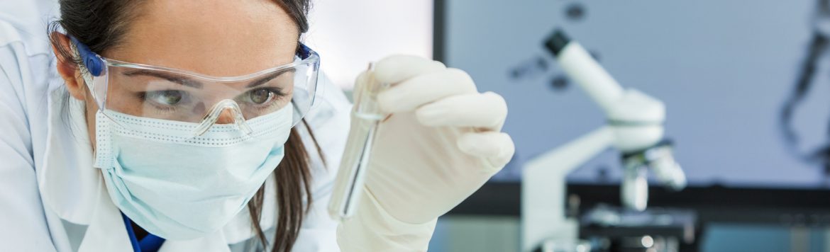 BioTalent Canada woman in a lab and lab gear holding a test tube.