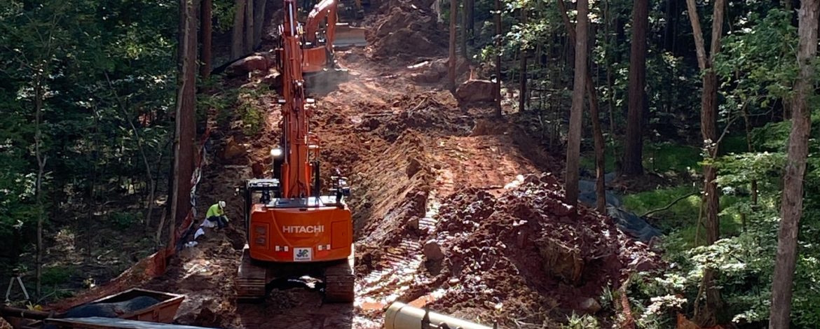 J.F. Wilkerson Contracting Company, Inc. excavators on a hillside with trees around.