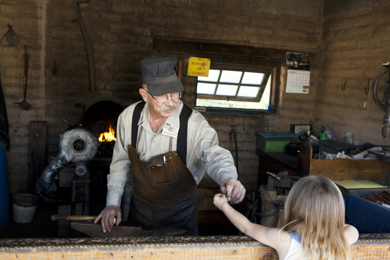Las Cruces, New Mexico Farm Ranch Museum showing a man dressed in period attire interacting with a young woman.