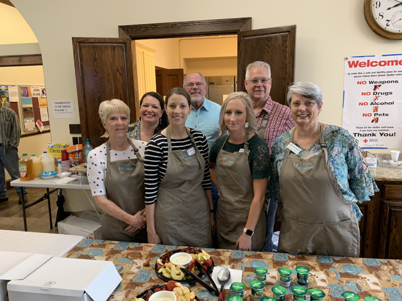 Mabrey Bank Red Cross Volunteers posing in front of a table with good.