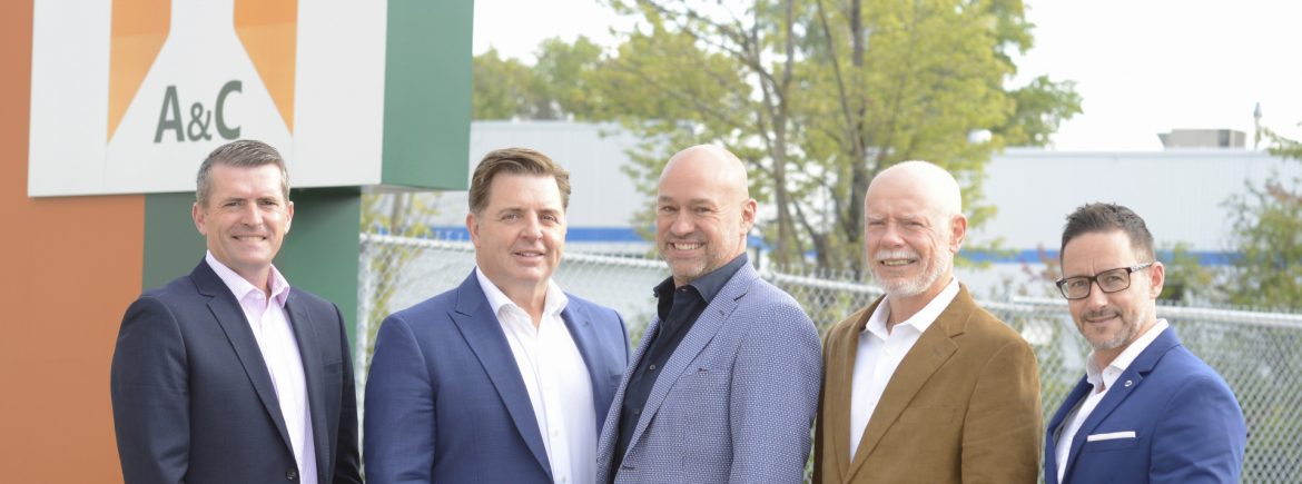 A&C Group photo in front of A&C sign.