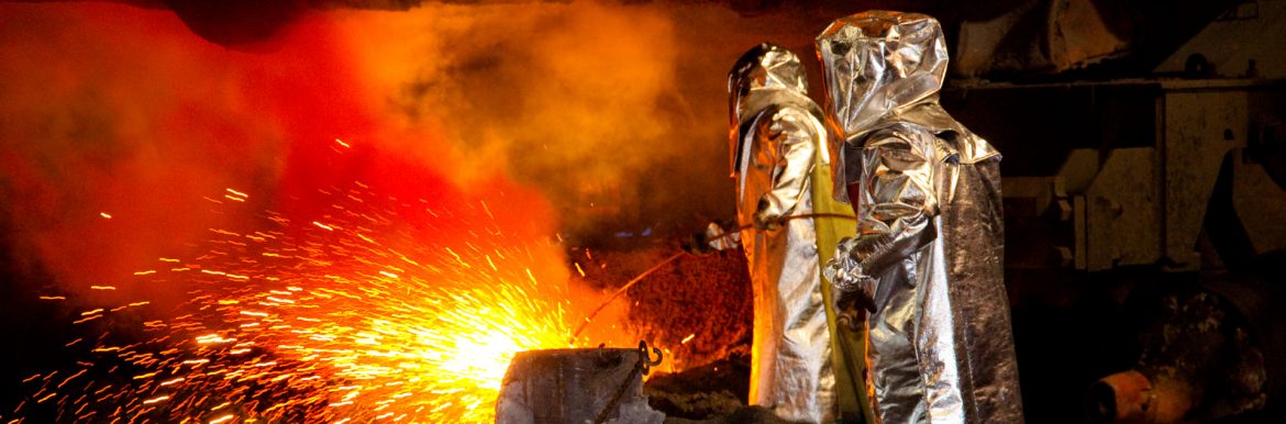 American Iron and Steel Institute workers in protective gear working with hot sparking metal.
