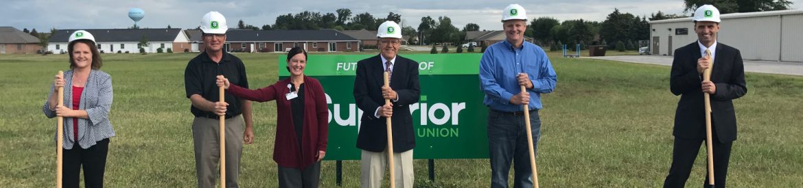 Superior Credit Union Coldwater Groundbreaking with 6 people standing with shovels wearing helmets for a groundbreaking ceremony