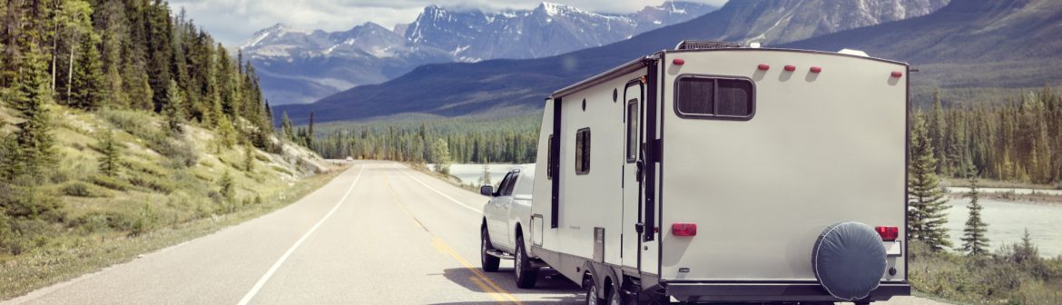 The Recreation Vehicle Industry Association RVIA trailer behind a truck in the mountains.