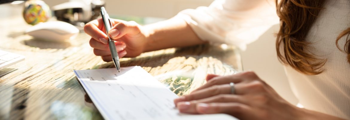 Blue Marble Global Payroll business woman signing a check.