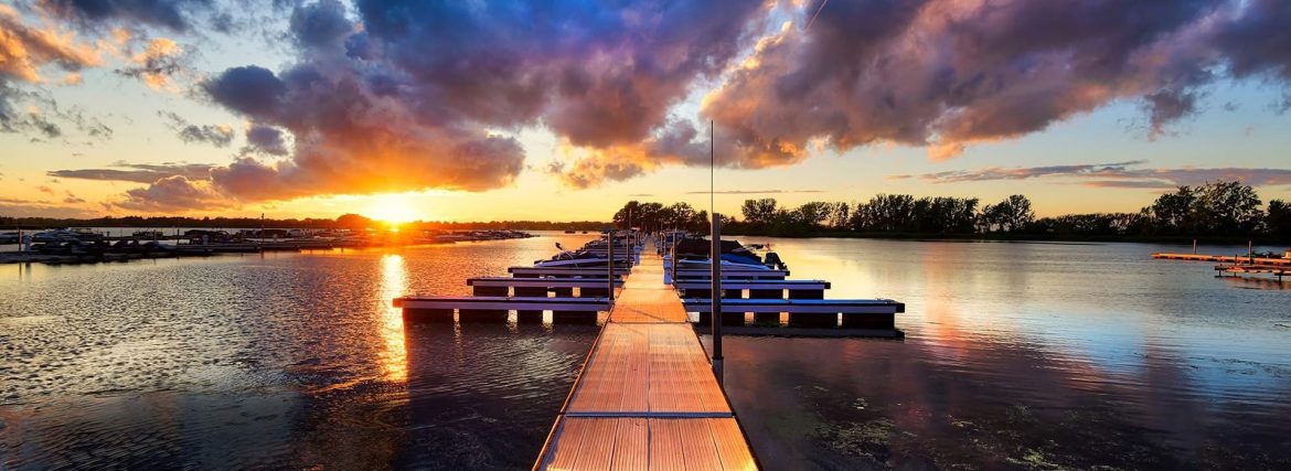 Boat dock with vibrant sunset reflection over water